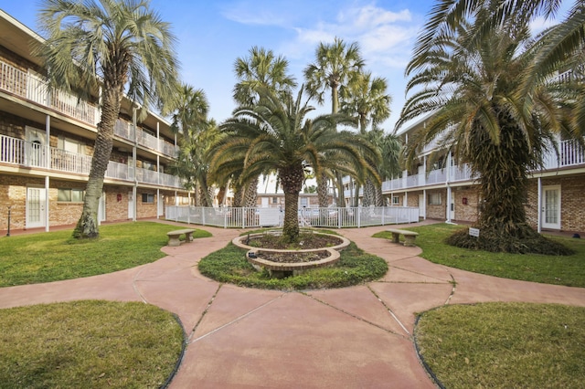 view of property's community featuring fence and a yard