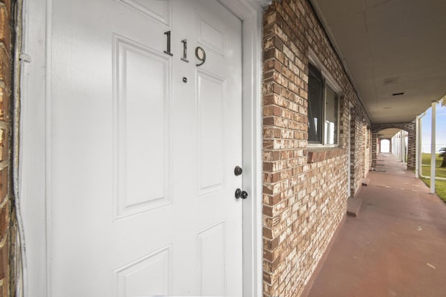 view of exterior entry featuring brick siding