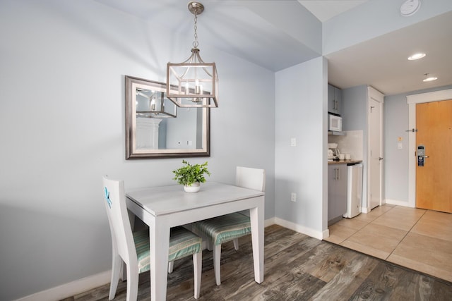 unfurnished dining area with hardwood / wood-style flooring and an inviting chandelier