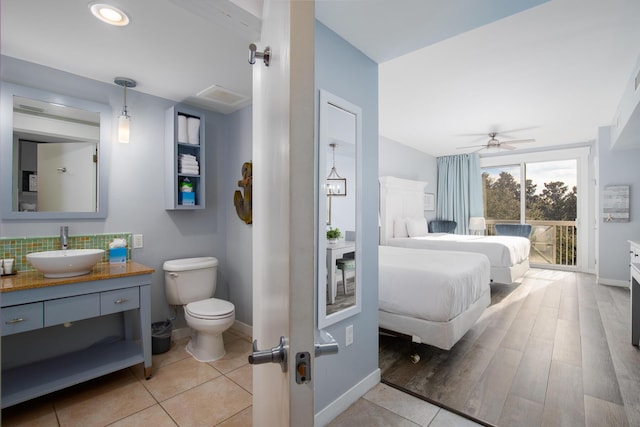 bathroom with decorative backsplash, vanity, ceiling fan, toilet, and tile patterned floors