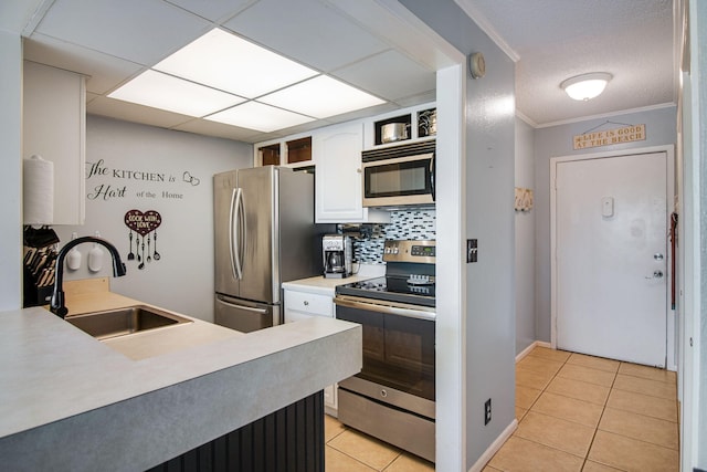 kitchen featuring sink, white cabinetry, light tile patterned floors, appliances with stainless steel finishes, and decorative backsplash