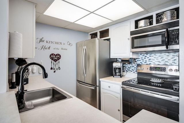 kitchen with sink, white cabinetry, a paneled ceiling, tasteful backsplash, and appliances with stainless steel finishes