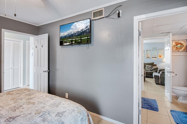 tiled bedroom with ceiling fan, crown molding, and a textured ceiling