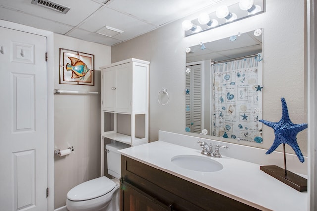 bathroom featuring vanity, a paneled ceiling, and toilet