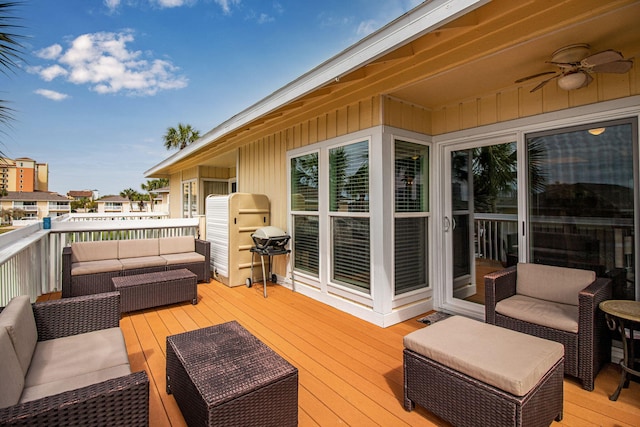 deck featuring grilling area, an outdoor hangout area, and ceiling fan