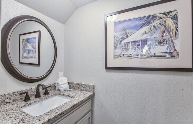 bathroom with vanity and vaulted ceiling