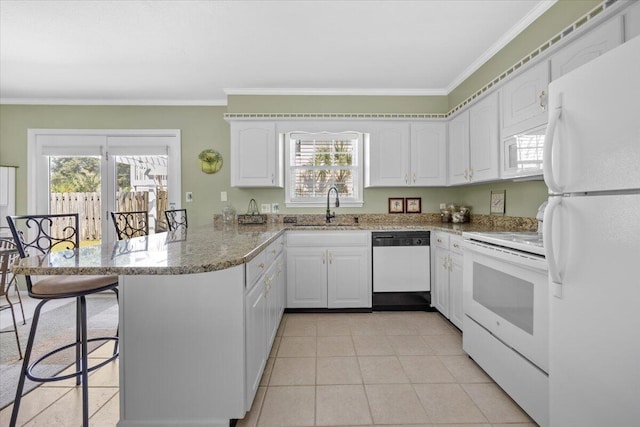 kitchen featuring white cabinetry, sink, white appliances, and kitchen peninsula