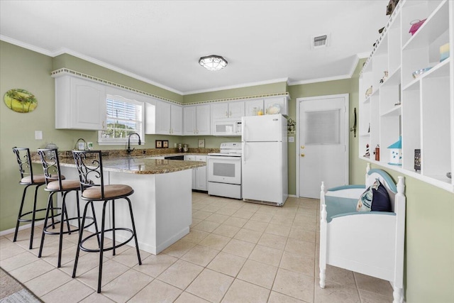 kitchen featuring stone counters, white cabinetry, a breakfast bar area, kitchen peninsula, and white appliances