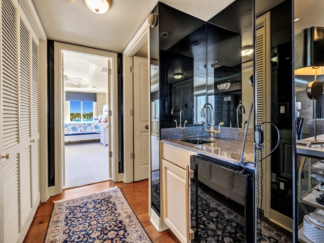 bathroom with hardwood / wood-style flooring, vanity, and beverage cooler