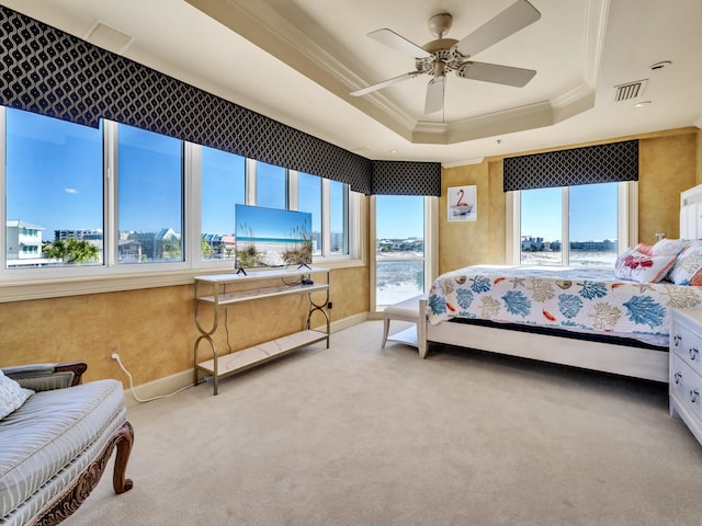 carpeted bedroom with ornamental molding, a raised ceiling, and ceiling fan