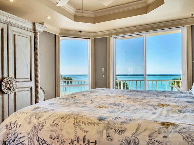 bedroom with a water view, crown molding, a raised ceiling, and access to outside