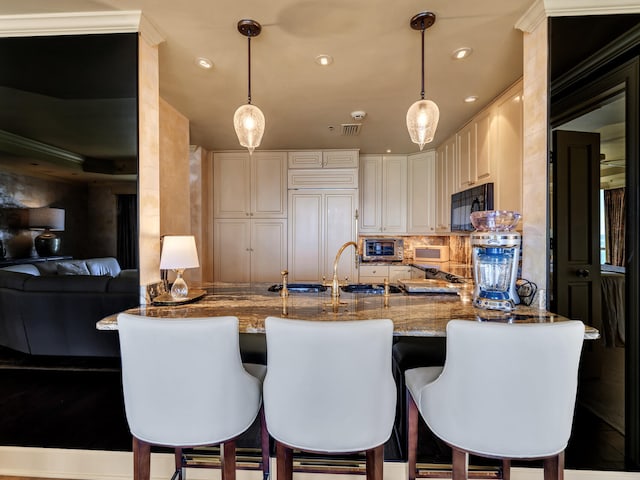 kitchen with decorative backsplash, paneled built in fridge, light stone countertops, and hanging light fixtures