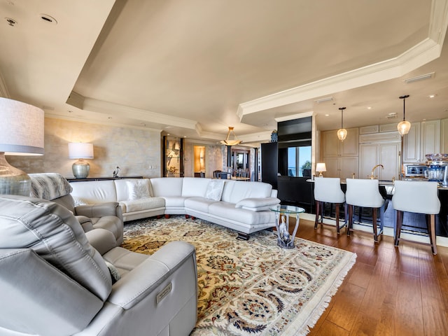 living room with crown molding, dark hardwood / wood-style floors, a raised ceiling, and sink