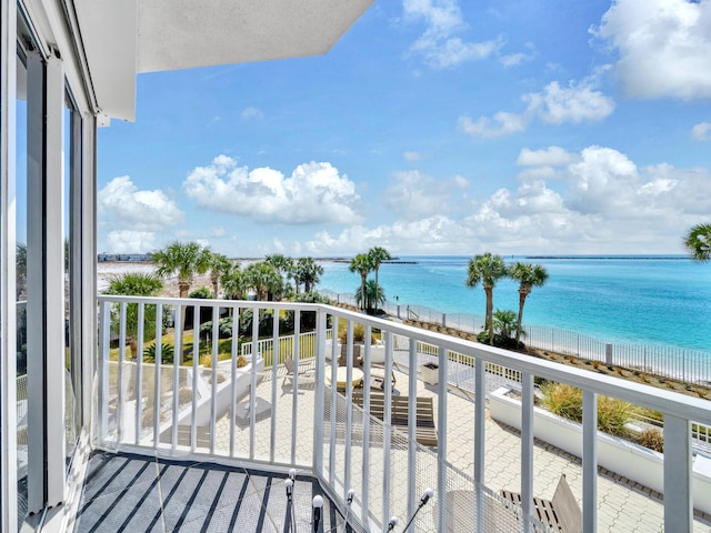 balcony featuring a water view and a beach view