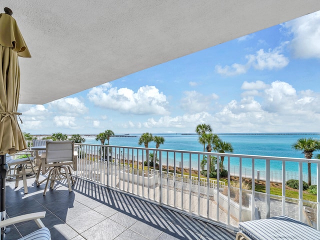 balcony with a water view and a beach view