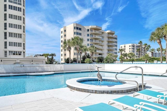 view of swimming pool with a hot tub and a patio area