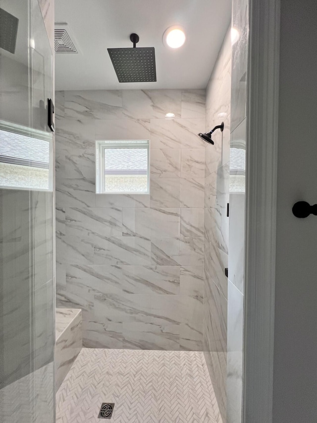 full bath featuring a marble finish shower and visible vents