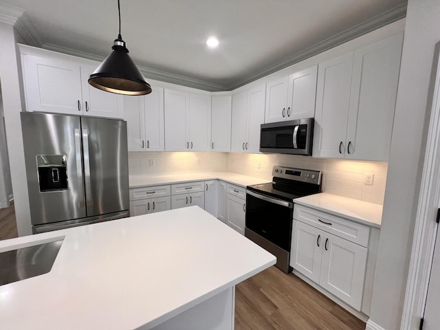 kitchen with backsplash, light countertops, wood finished floors, white cabinets, and stainless steel appliances