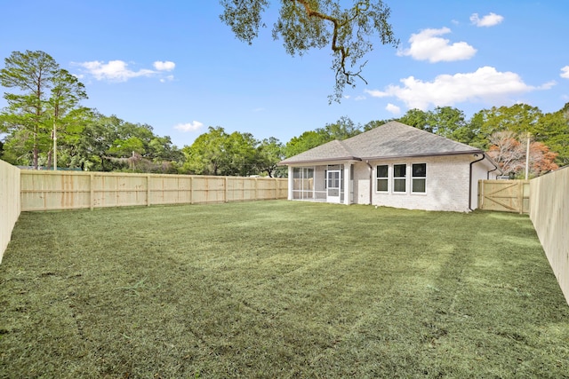 view of yard with a fenced backyard and a sunroom