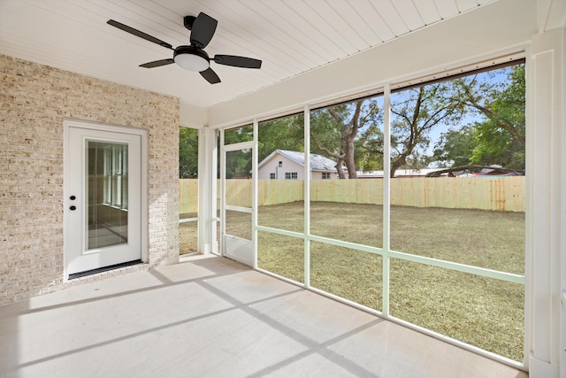 unfurnished sunroom featuring plenty of natural light and a ceiling fan