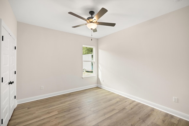 unfurnished room featuring a ceiling fan, light wood-type flooring, and baseboards