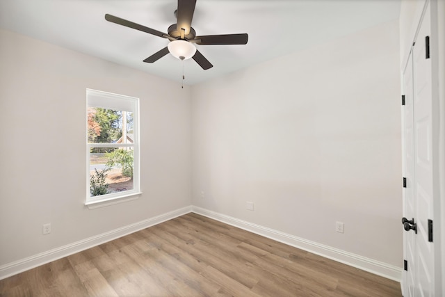 empty room with ceiling fan, light wood-type flooring, and baseboards