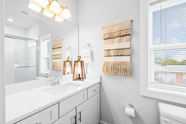 bathroom with an enclosed shower, vanity, and toilet