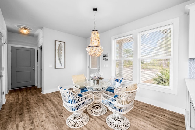 dining space with hardwood / wood-style flooring and a chandelier