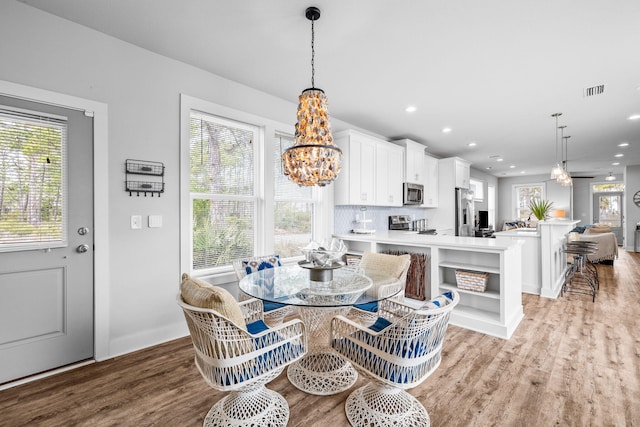 dining room featuring a notable chandelier and light hardwood / wood-style flooring