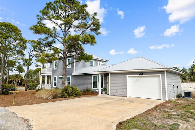 view of front of house with a garage, a balcony, and cooling unit