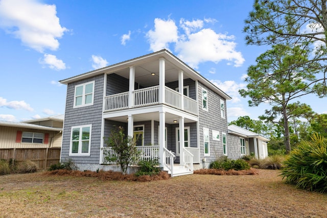 view of front of house with a balcony, a front yard, and covered porch