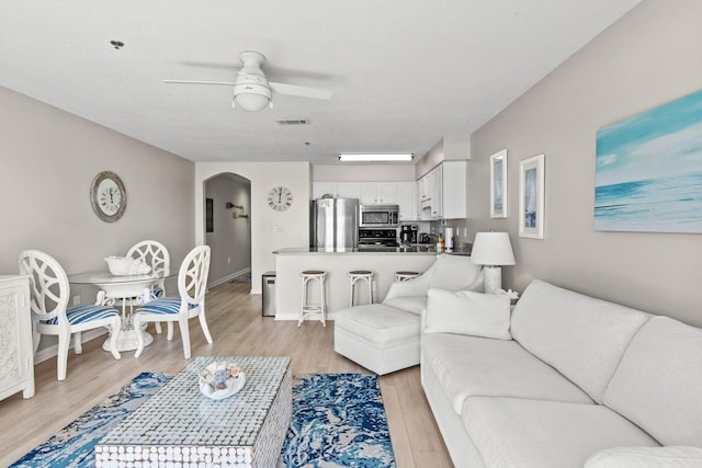 living room with ceiling fan and light wood-type flooring