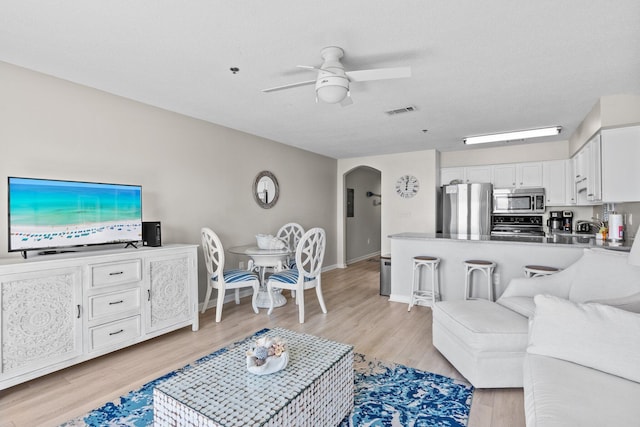 living room featuring ceiling fan and light hardwood / wood-style flooring