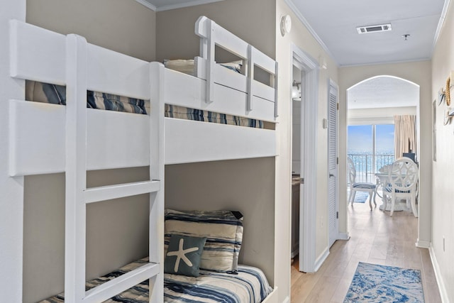 bedroom featuring crown molding and light hardwood / wood-style floors