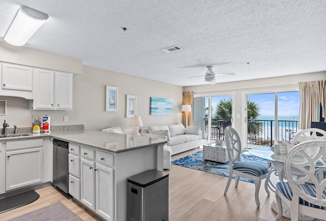 kitchen featuring white cabinetry, kitchen peninsula, stainless steel appliances, a water view, and light hardwood / wood-style flooring