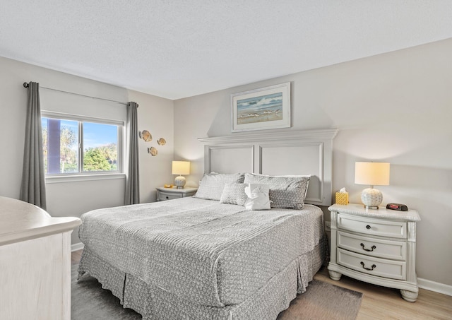 bedroom featuring a textured ceiling and light hardwood / wood-style flooring