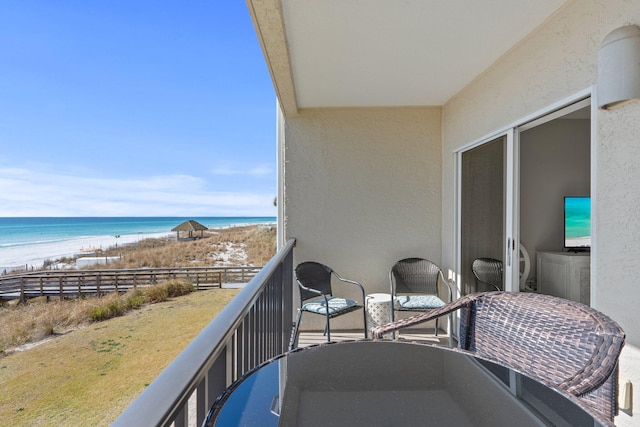 balcony featuring a water view and a view of the beach