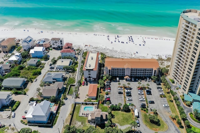 birds eye view of property with a water view and a beach view