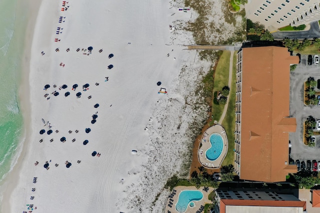 drone / aerial view featuring a water view and a view of the beach