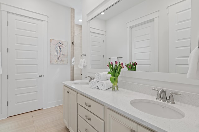 bathroom with tile patterned floors, a sink, and double vanity