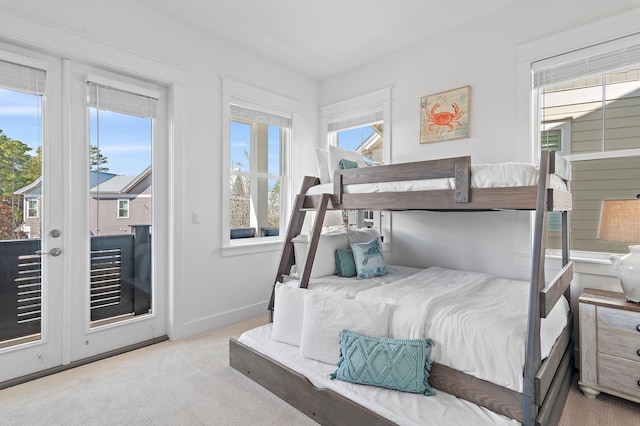 carpeted bedroom with access to outside, multiple windows, and baseboards