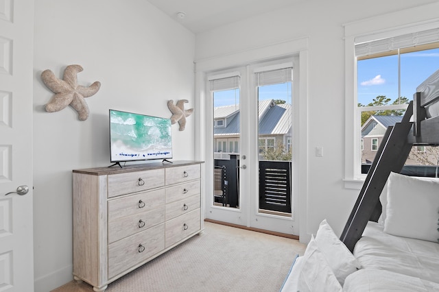 bedroom featuring access to outside, french doors, multiple windows, and light colored carpet