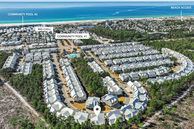 drone / aerial view featuring a beach view, a residential view, and a water view