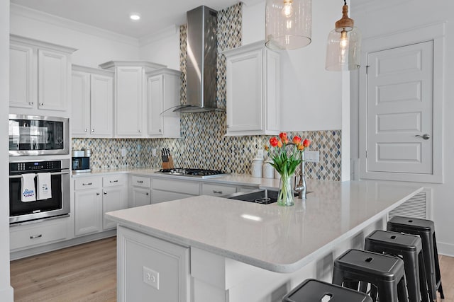 kitchen with stainless steel appliances, backsplash, and wall chimney range hood