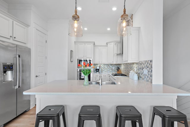 kitchen with stainless steel appliances, light countertops, backsplash, and a peninsula