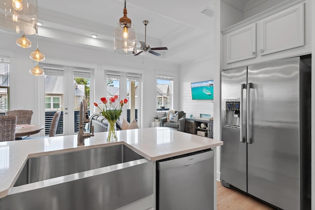 kitchen featuring open floor plan, stainless steel appliances, plenty of natural light, and a sink