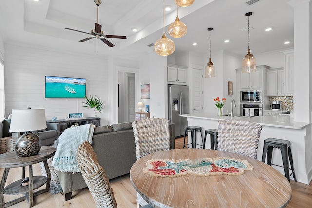 dining room featuring a ceiling fan, light wood-type flooring, a raised ceiling, and recessed lighting