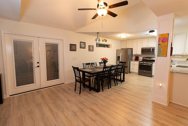 dining space featuring light hardwood / wood-style flooring, sink, lofted ceiling, ceiling fan, and french doors