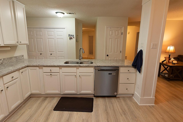 kitchen with light hardwood / wood-style floors, sink, light stone counters, and stainless steel dishwasher