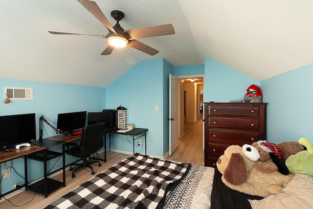 bedroom featuring ceiling fan, light hardwood / wood-style flooring, a textured ceiling, and lofted ceiling